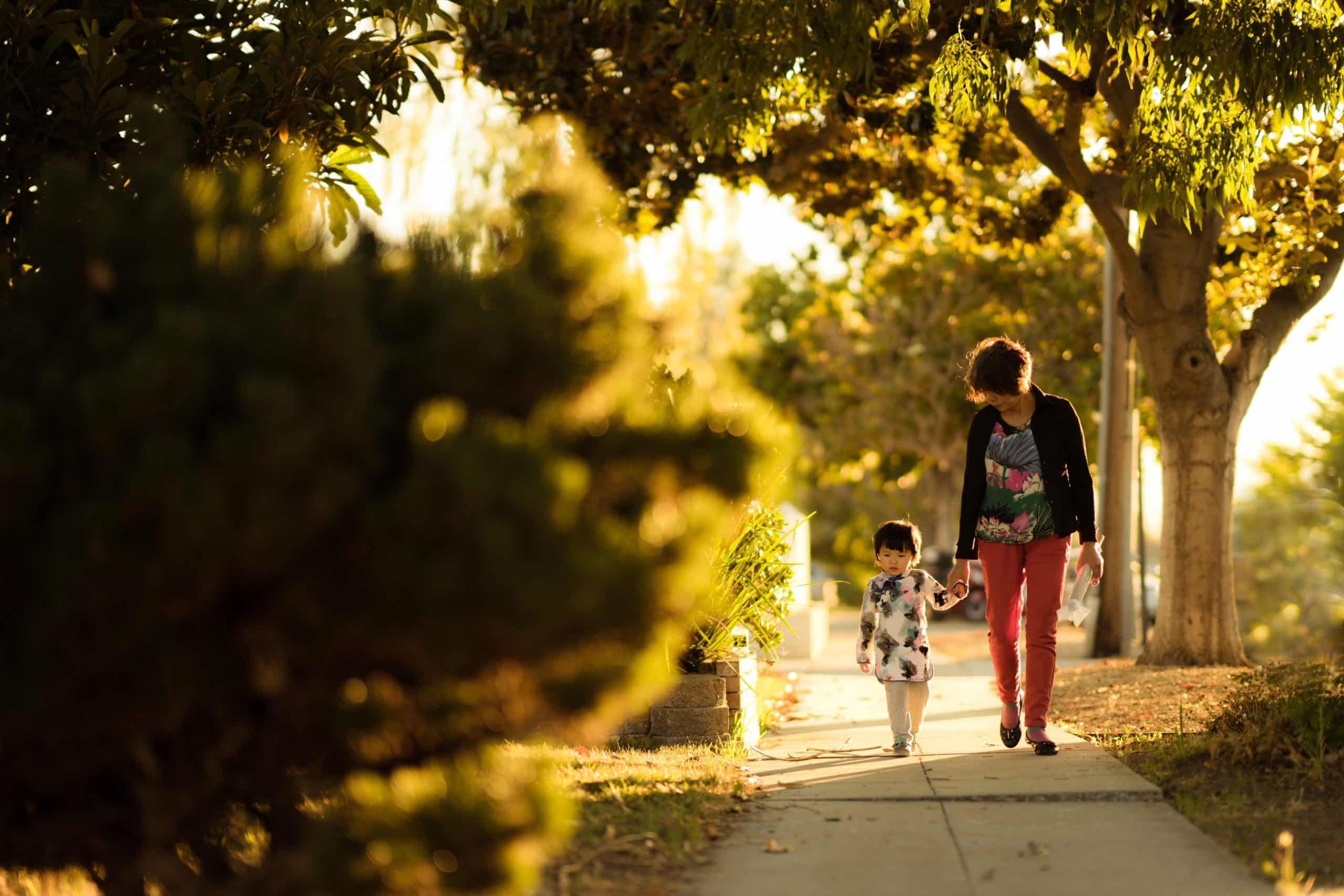 woman and child walking down sidewalk in need of concrete lifting due to trip hazard