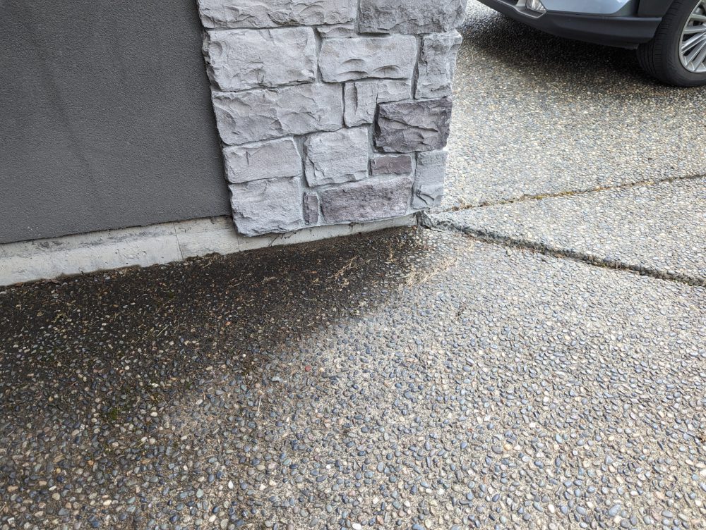 sunken walkway with negative slope which allows water to sit against the foundation